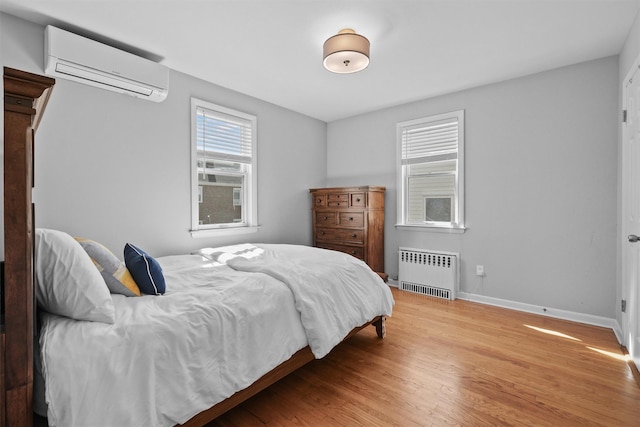 269 Hayward St, Yonkers, NY 10704 - bedroom featuring radiator, an AC wall unit, wood finished floors, and baseboards