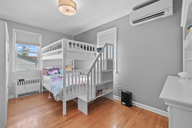 269 Hayward St, Yonkers, NY 10704 - bedroom with radiator heating unit, a wall unit AC, wood finished floors, and baseboards
