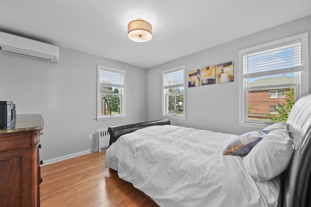 269 Hayward St, Yonkers, NY 10704 - bedroom featuring a wall mounted air conditioner, light wood finished floors, baseboards, and radiator heating unit