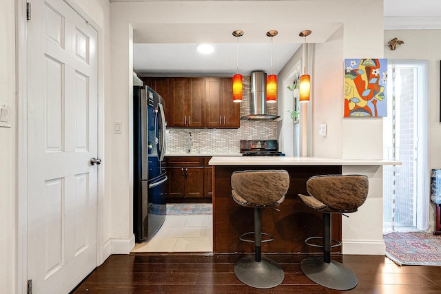 67-66 108th St Unit A32, Forest Hills, NY 11375 - kitchen featuring wall chimney exhaust hood, appliances with stainless steel finishes, baseboards, light wood finished floors, and backsplash