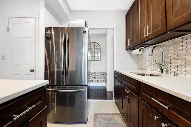 67-66 108th St Unit A32, Forest Hills, NY 11375 - kitchen with freestanding refrigerator, a sink, light countertops, decorative backsplash, and dark brown cabinetry