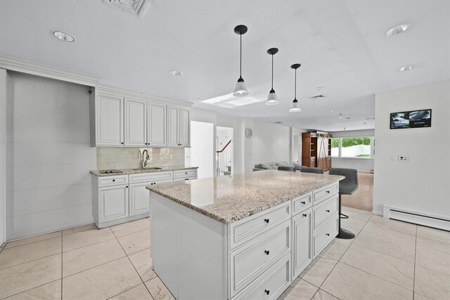32 Wilder Rd, Monsey, NY 10952 - kitchen featuring a sink, open floor plan, decorative light fixtures, light stone counters, and light tile patterned floors