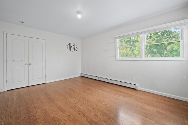 32 Wilder Rd, Monsey, NY 10952 - unfurnished bedroom featuring baseboard heating, wood finished floors, baseboards, and a closet