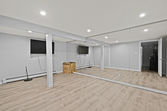 32 Wilder Rd, Monsey, NY 10952 - finished below grade area with recessed lighting, wood finished floors, baseboard heating, baseboards, and a baseboard radiator