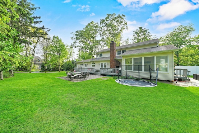 32 Wilder Rd, Monsey, NY 10952 - rear view of house featuring a wooden deck, a lawn, a chimney, and a patio area