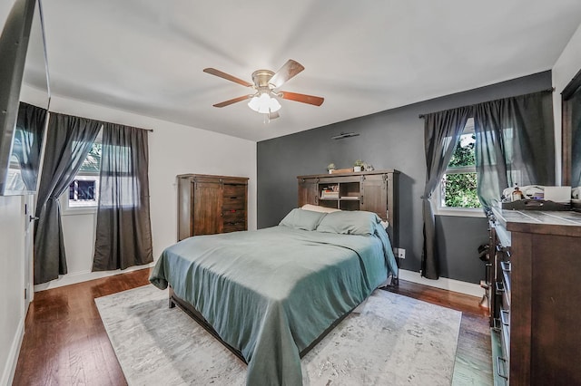 bedroom featuring multiple windows, wood finished floors, and baseboards