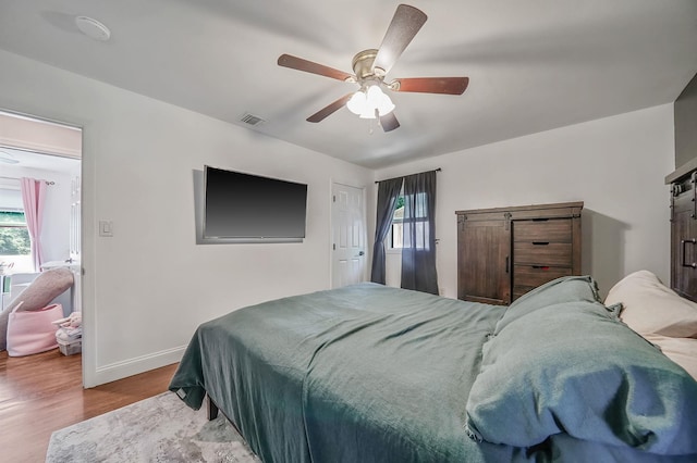 bedroom featuring wood finished floors, baseboards, and ceiling fan