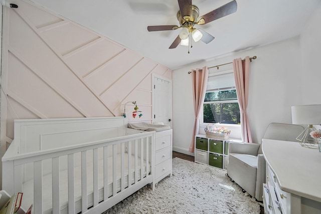 bedroom with a crib and ceiling fan