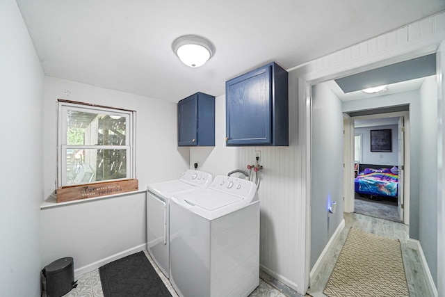 laundry area with cabinet space, independent washer and dryer, baseboards, and light wood-type flooring