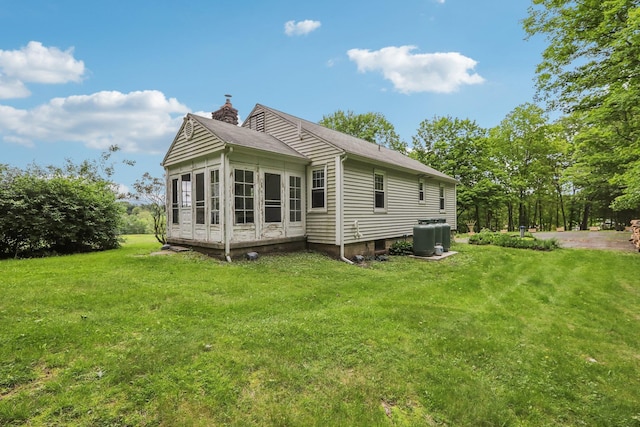 275 Otterkill Rd, Cornwall, NY 12553 - rear view of property featuring a chimney, a lawn, a sunroom, a shingled roof, and central AC unit