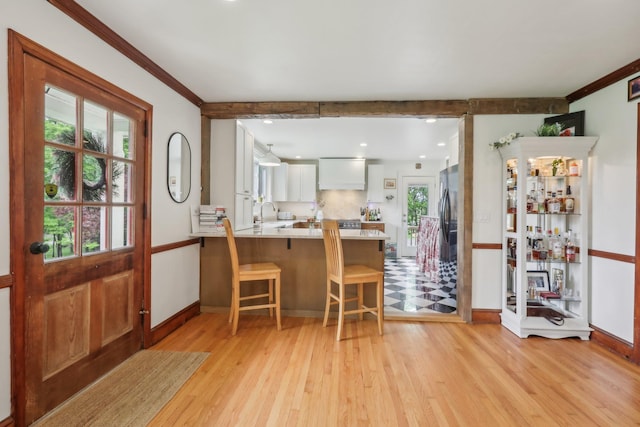275 Otterkill Rd, Cornwall, NY 12553 - kitchen featuring light wood-style flooring, a peninsula, ornamental molding, freestanding refrigerator, and light countertops