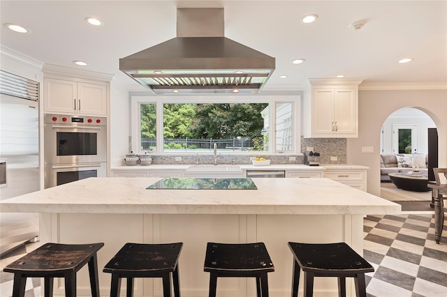 50 Kerry Ln, Chappaqua, NY 10514 - kitchen with wall chimney range hood, stainless steel appliances, arched walkways, light countertops, and ornamental molding
