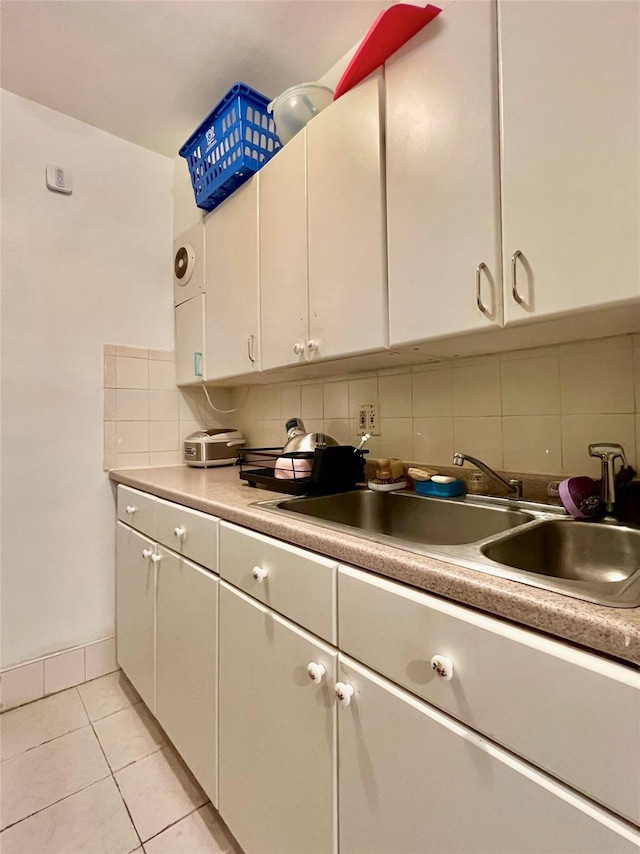142-05 Roosevelt Ave Unit 301, Flushing, NY 11354 - kitchen featuring a sink, decorative backsplash, white cabinetry, and light tile patterned flooring