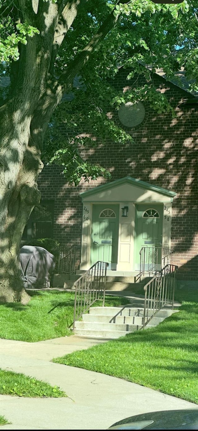 245-60 62nd Ave Unit F-5, Little Neck, NY 11362 - view of exterior entry featuring brick siding and a lawn