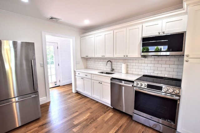 9 Circuit Rd, Bellport Village, NY 11713 - kitchen with appliances with stainless steel finishes, a sink, crown molding, decorative backsplash, and white cabinets