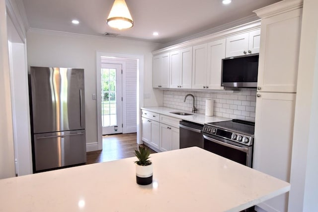 9 Circuit Rd, Bellport Village, NY 11713 - kitchen featuring stainless steel appliances, light countertops, a sink, tasteful backsplash, and ornamental molding
