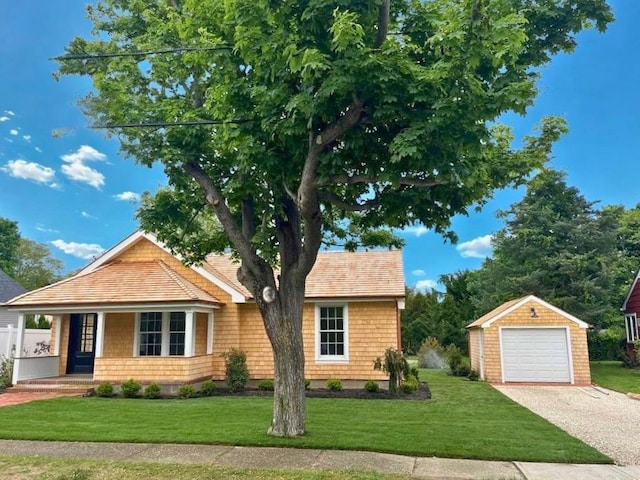 9 Circuit Rd, Bellport Village, NY 11713 - view of front of property featuring an outdoor structure, asphalt driveway, a front lawn, and a garage