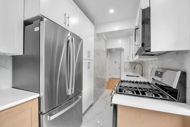 99-52 66th Rd Unit 3G, Rego Park, NY 11374 - kitchen with appliances with stainless steel finishes, light marble finish floors, white cabinets, recessed lighting, and light countertops