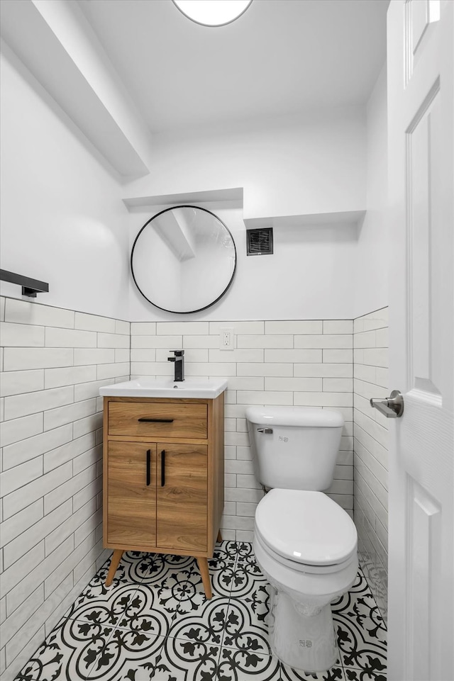 99-52 66th Rd Unit 3G, Rego Park, NY 11374 - half bath featuring tile walls, vanity, tile patterned flooring, and a wainscoted wall