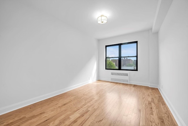 99-52 66th Rd Unit 3G, Rego Park, NY 11374 - unfurnished room featuring radiator heating unit and light wood-style flooring