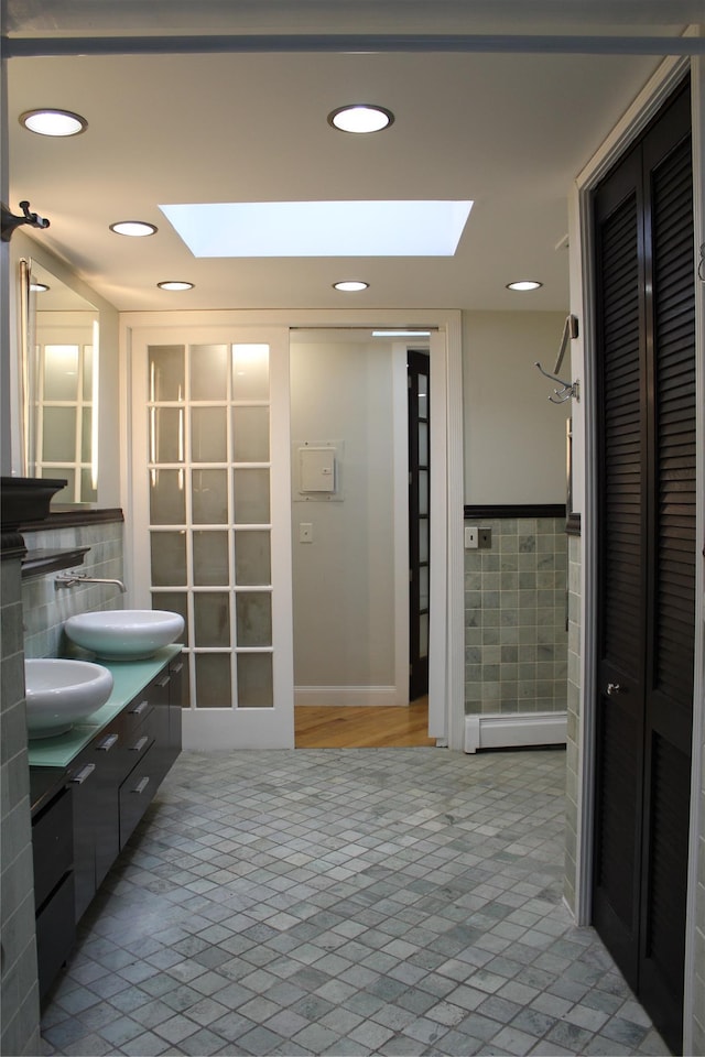 1234East37thStreet E, Brooklyn, NY 11210 - bathroom featuring a skylight, a closet, double vanity, tile walls, and recessed lighting
