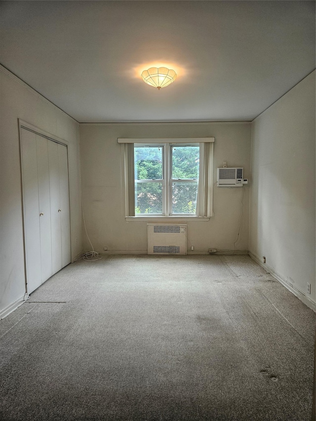 1361 Broadway Unit B26, Hewlett, NY 11557 - unfurnished bedroom with radiator, carpet flooring, a wall unit AC, and a closet