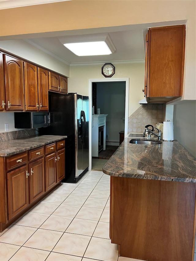 662 Gillette Ave, Bayport, NY 11705 - kitchen featuring a sink, black microwave, backsplash, a fireplace, and brown cabinetry