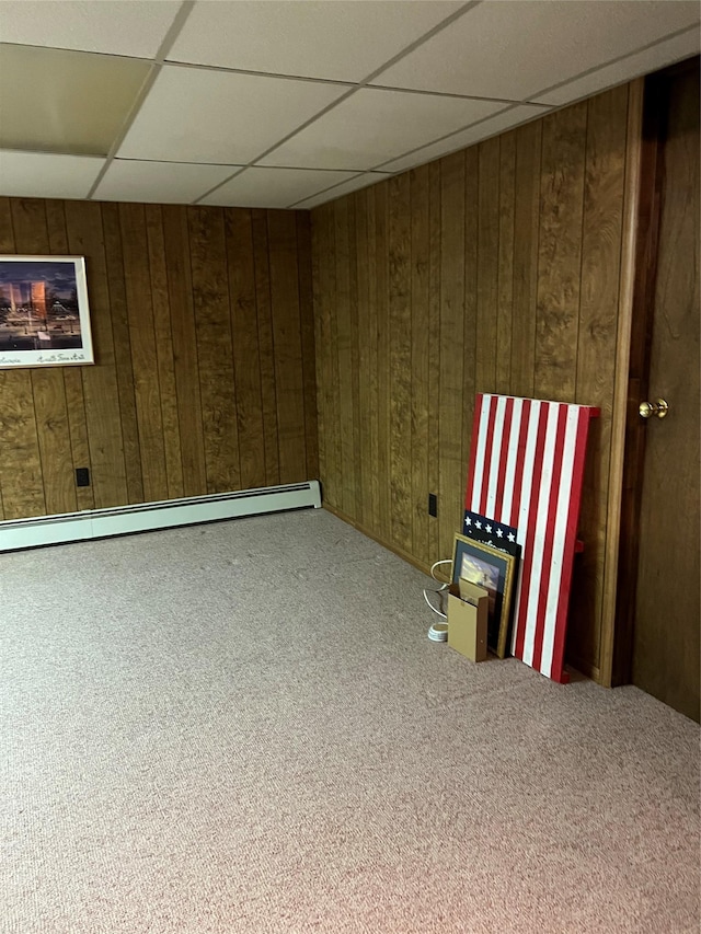 662 Gillette Ave, Bayport, NY 11705 - carpeted empty room with a drop ceiling, a baseboard radiator, and wood walls