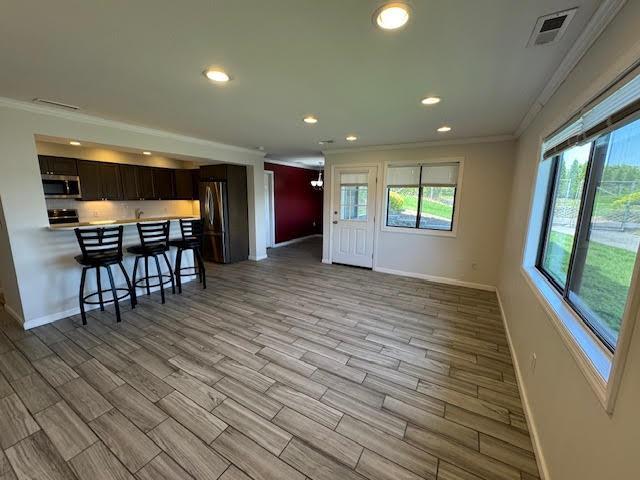 350 N Water St Unit 1-7, Newburgh, NY 12550 - kitchen featuring stainless steel appliances, ornamental molding, a kitchen breakfast bar, baseboards, and healthy amount of natural light