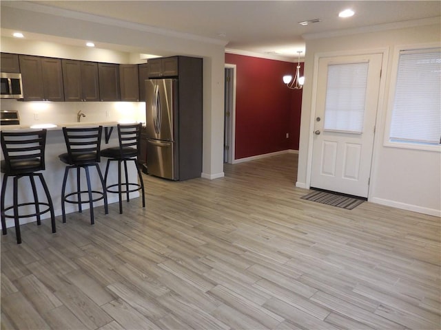 350 N Water St Unit 1-7, Newburgh, NY 12550 - kitchen featuring stainless steel appliances, crown molding, a breakfast bar, dark brown cabinetry, and baseboards