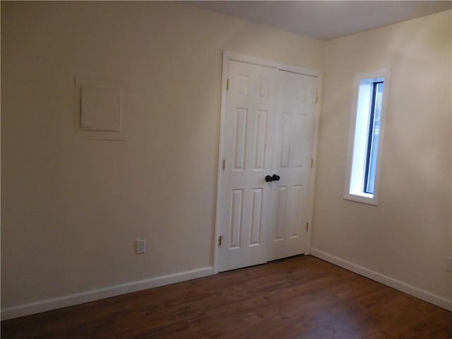 350 N Water St Unit 1-7, Newburgh, NY 12550 - unfurnished bedroom featuring multiple windows, dark wood-style flooring, baseboards, and a closet