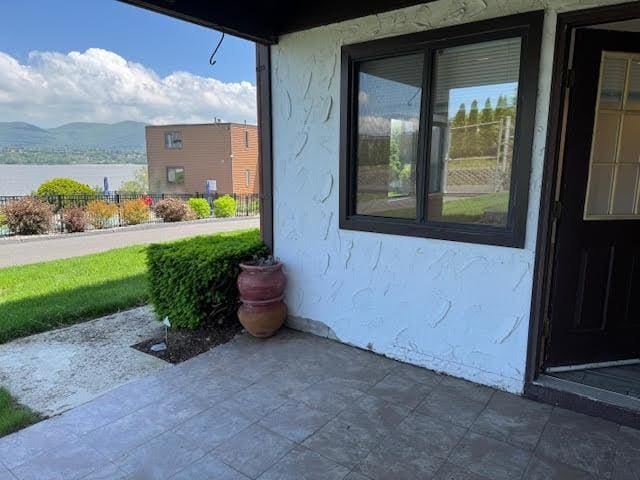 350 N Water St Unit 1-7, Newburgh, NY 12550 - view of exterior entry with stucco siding, a patio area, and a mountain view