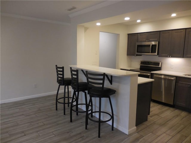 350 N Water St Unit 1-7, Newburgh, NY 12550 - kitchen with stainless steel appliances, a kitchen breakfast bar, wood finished floors, crown molding, and light countertops