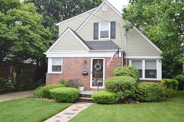 145 Gerard Ave, New Hyde Park, NY 11040 - view of front of house with a front lawn, brick siding, and roof with shingles