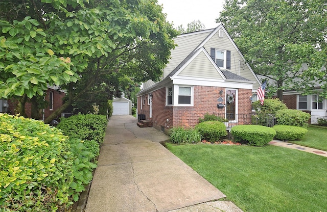 145 Gerard Ave, New Hyde Park, NY 11040 - bungalow-style house with brick siding, an outbuilding, a detached garage, and a front lawn