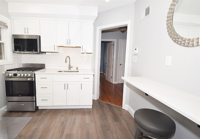 145 Gerard Ave, New Hyde Park, NY 11040 - kitchen with stainless steel appliances, dark wood-style flooring, light countertops, and white cabinets
