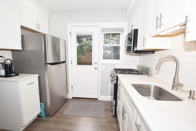 145 Gerard Ave, New Hyde Park, NY 11040 - kitchen with stainless steel appliances, white cabinetry, dark wood finished floors, tasteful backsplash, and light countertops