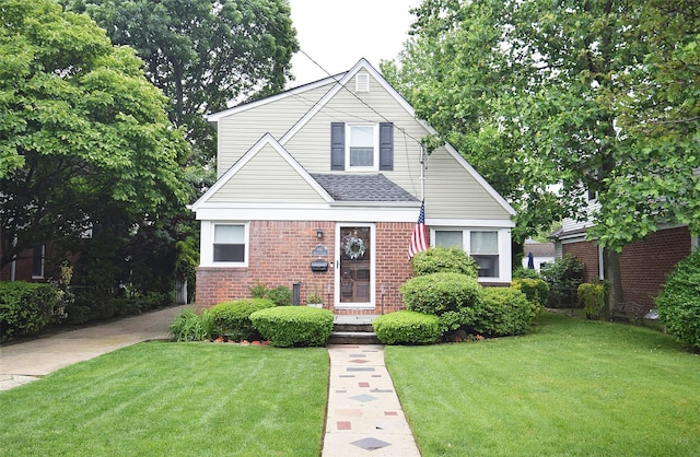 145 Gerard Ave, New Hyde Park, NY 11040 - view of front of home with brick siding, a front yard, and roof with shingles