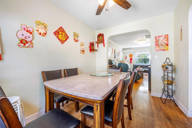 20-29 150th St, Whitestone, NY 11357 - dining space with arched walkways, a ceiling fan, wood finished floors, baseboards, and a wall mounted air conditioner