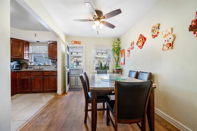 20-29 150th St, Whitestone, NY 11357 - dining area featuring healthy amount of natural light, a ceiling fan, light wood-style floors, and baseboards