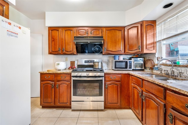 20-29 150th St, Whitestone, NY 11357 - kitchen with stainless steel appliances, a sink, light tile patterned floors, brown cabinetry, and light stone countertops
