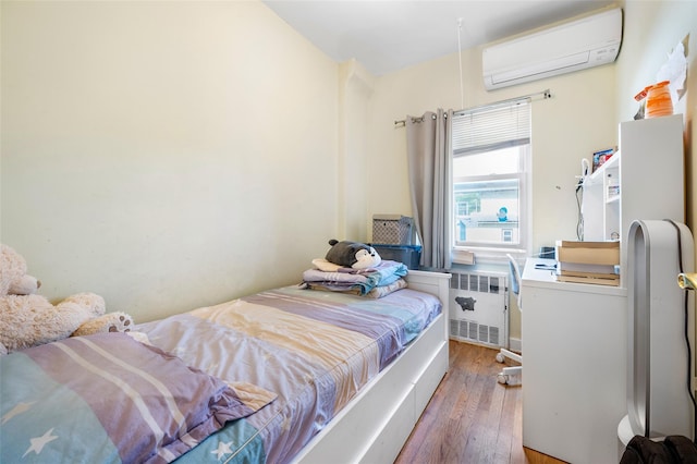20-29 150th St, Whitestone, NY 11357 - bedroom featuring radiator heating unit, hardwood / wood-style flooring, and a wall mounted air conditioner