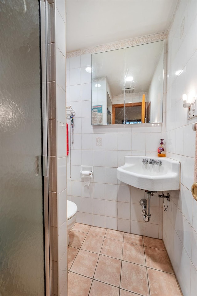 20-29 150th St, Whitestone, NY 11357 - full bathroom featuring tile walls, a stall shower, tile patterned flooring, toilet, and a sink