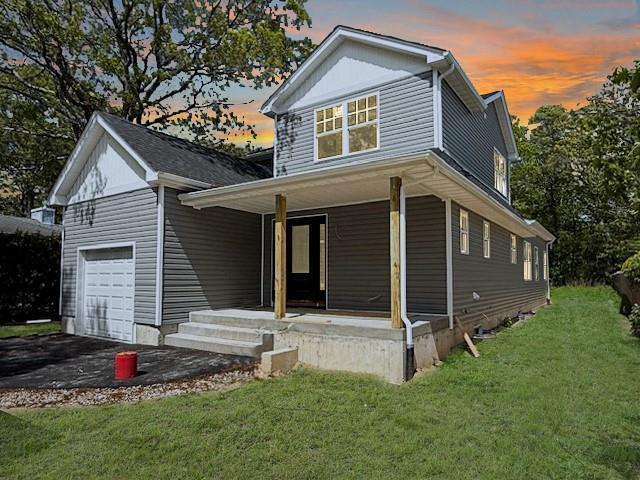 114 W End Dr, Shirley, NY 11967 - view of front of house with covered porch, a garage, and a front yard