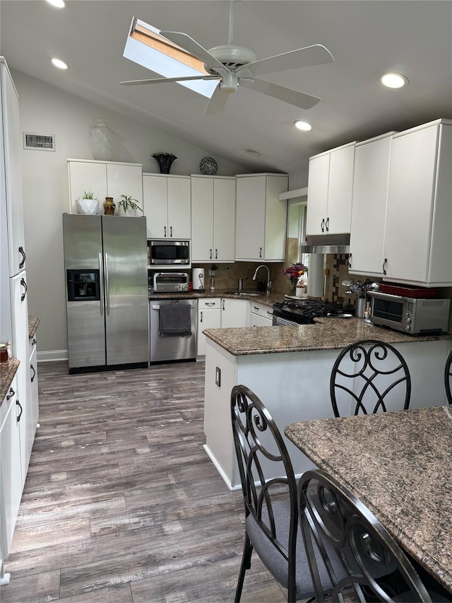 15 Spruce Ct, Nanuet, NY 10954 - kitchen with stainless steel appliances, lofted ceiling, a ceiling fan, a peninsula, and white cabinets