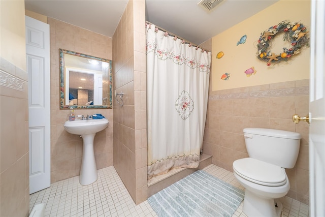 3225 155th St, Flushing, NY 11354 - bathroom with tile walls, toilet, tile patterned flooring, a shower with curtain, and a wainscoted wall