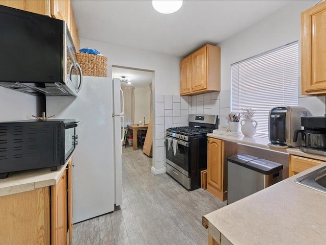 429 Revere Ave, Bronx, NY 10465 - kitchen with stainless steel appliances, light wood-style flooring, decorative backsplash, and light countertops