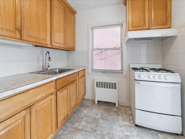 429 Revere Ave, Bronx, NY 10465 - kitchen featuring radiator, white gas range oven, a sink, under cabinet range hood, and light countertops