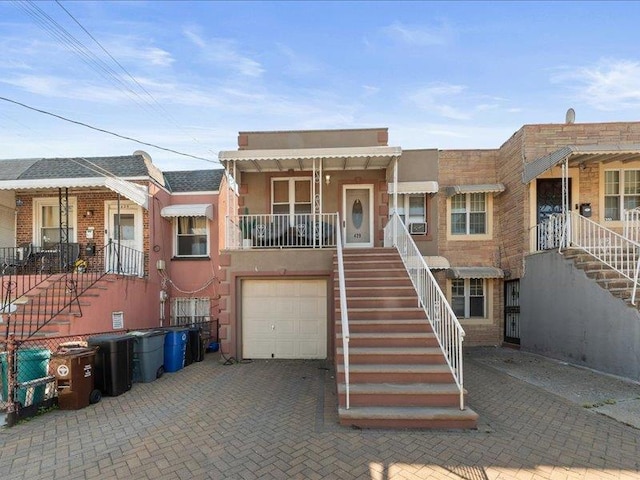 429 Revere Ave, Bronx, NY 10465 - view of front of home featuring stairs, an attached garage, decorative driveway, and stucco siding