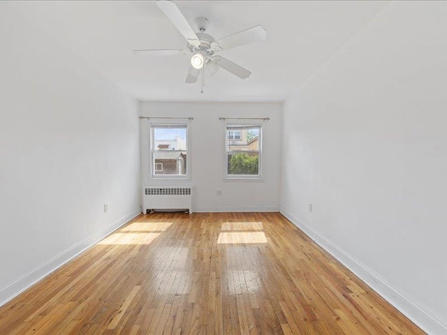 429 Revere Ave, Bronx, NY 10465 - spare room featuring radiator heating unit, baseboards, light wood-style flooring, and a ceiling fan